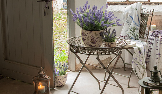 A romantic garden with lavender flower pots and an iron plant holder