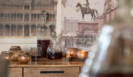 Glass bottles filled with beverages and brown tea light holders