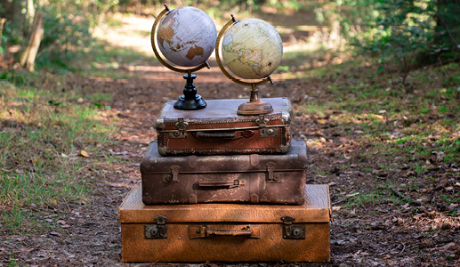 Three stacked antique trunks with two world globes on top