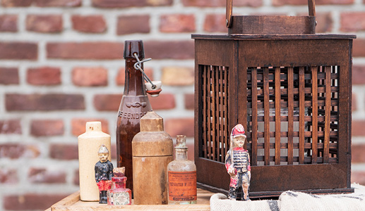 Un photophore en bois avec des figurines et des bouteilles antiques