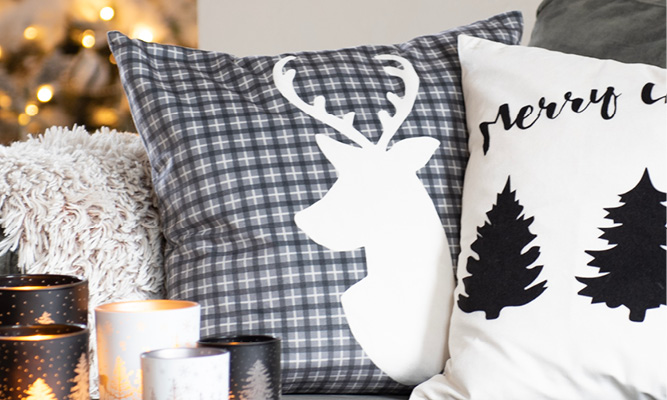 Un cuscino con un motivo a quadri grigi e un cervo bianco sopra